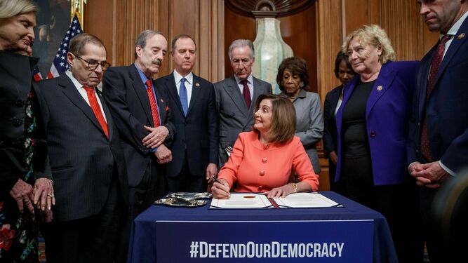 La presidenta de la Cámara de Representantes, Nancy Pelosi, con los presidentes de los comités y los encargados de juicio político, firma sus artículos.
