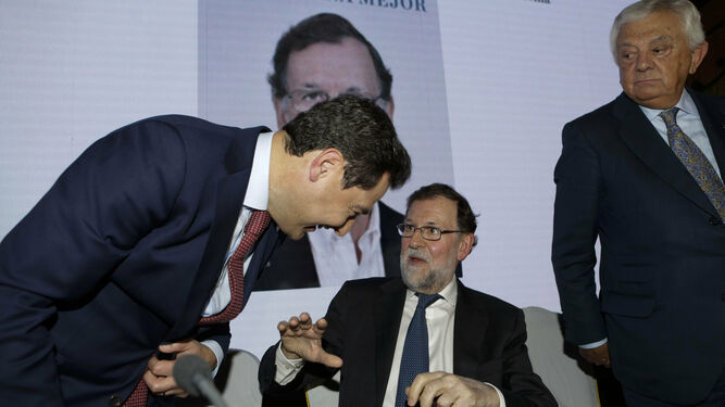 Juanma Moreno bromea con Mariano Rajoy, en el hotel Alfonso XIII.