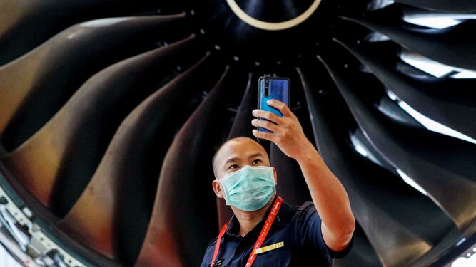 Un hombre protegido con una mascarilla se hace una foto este martes en Singapur durante la feria de aviación.