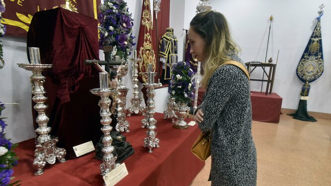 Una joven observa varios candelabros en la muestra de enseres cofrades de La Línea, este sábado.