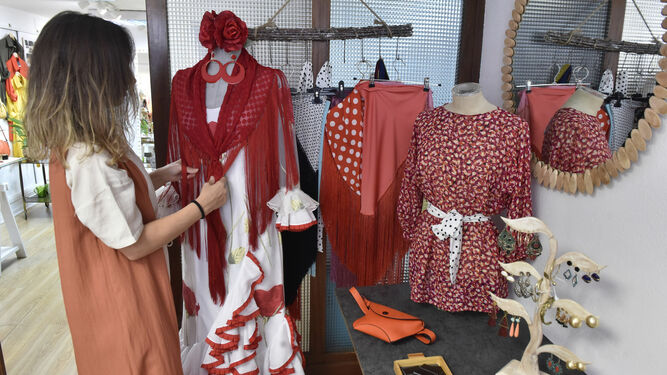 Susana Pagés, en su tienda de Los Remedios, con uno de sus trajes de flamenca.