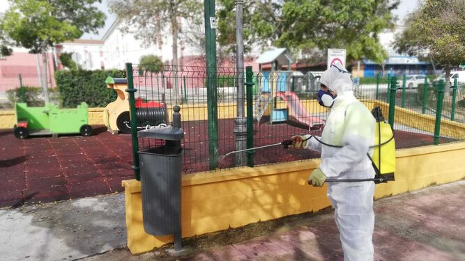 Un operario municipal desinfecta una zona de juegos en un parque.