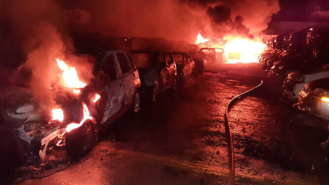 Imagen del interior del desguace, con varios vehículos ardiendo.