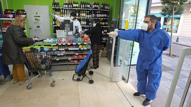 Trabajadores de un supermercado organizan a sus clientes en el interior del comercio.