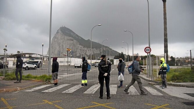 Un polic&iacute;a nacional organiza la fila de entrada de trabajadores transfronterizos a Gibraltar.