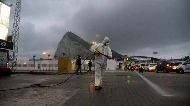 Un operario municipal desinfecta la acera fronteriza con Gibraltar.