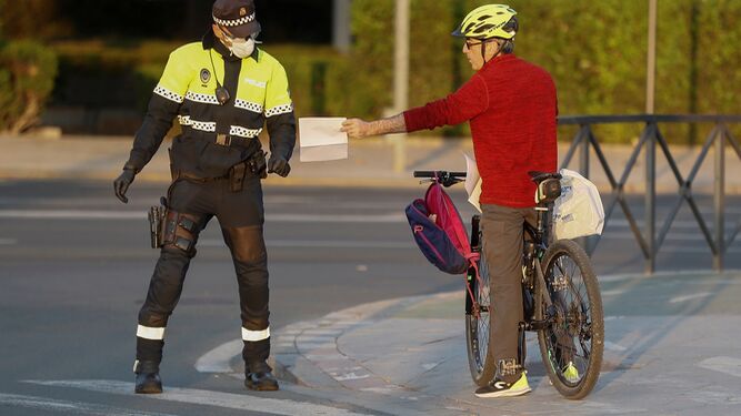 Un Policía Local requiere la justificación a un ciclistas en Sevilla.