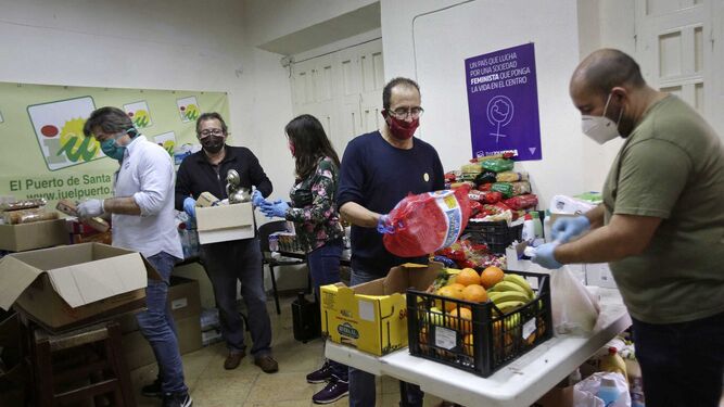Los voluntarios de la red de solidaridad Los Invisibles, trabajando para elaborar los kits de alimentos.