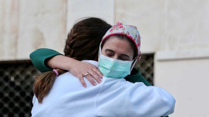 Personal sanitario abrazándose en el exterior del Puerta del Mar.
