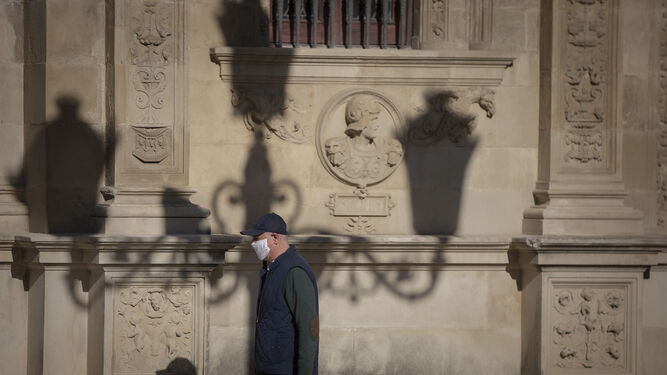 Un hombre pasea, con mascarillas, por Sevilla.