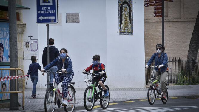 Dos niños y una mujer pasean en bicicleta en Sevilla