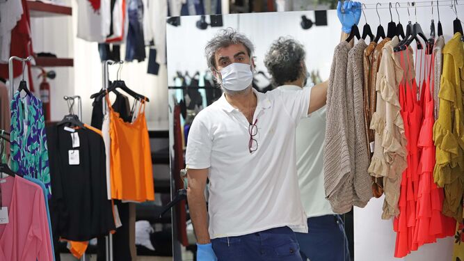 Juan Perea, propietario de la Boutique Pirámide Algeciras, en su negocio con guantes y mascarilla.