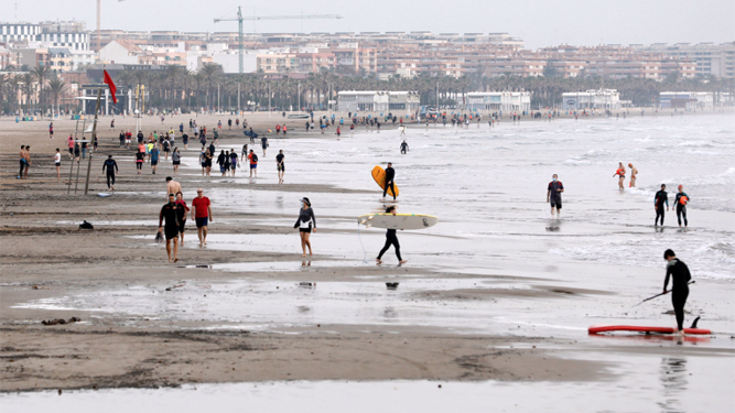 Numerosas personas pasean en la valenciana playa de la Malvarrosa durante la franja horaria permitida.