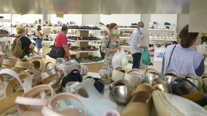 Varios clientes miran zapatos en una tienda del centro de Algeciras.