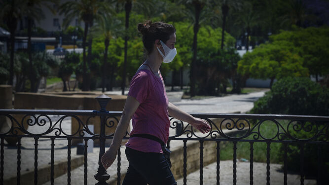 Una joven pasea con mascarilla.