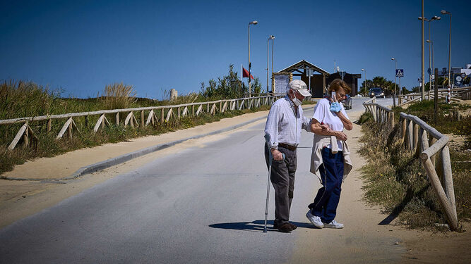 Playas de Vejer. Dos personas caminan por el paseo mar&iacute;timo de El Palmar.