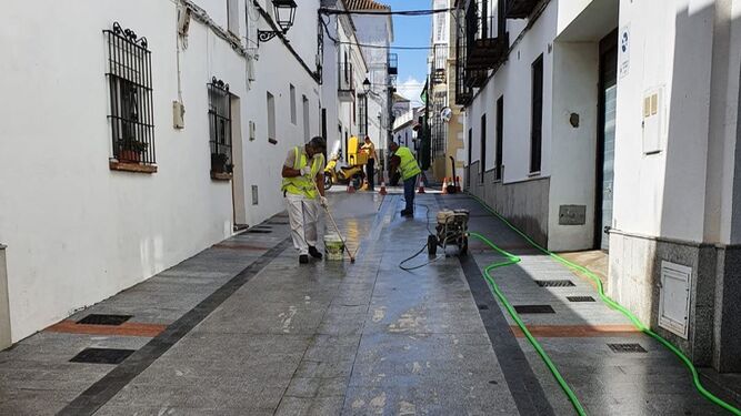 Labores de protección del pavimento en la calle Málaga de San Roque.