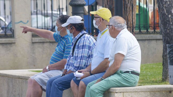Cuatro hombres comparten asiento en el centro de San Roque.
