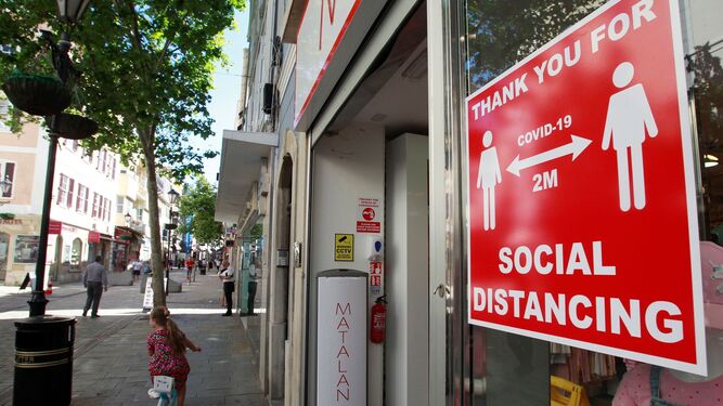 Un escaparate en Gibraltar con un cartel que solicita mantener la distancia social.