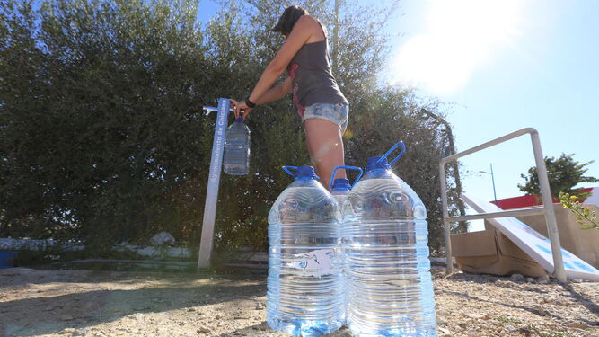 Una mujer recarga garrafas de agua en uno de los puntos de suministro instalados por el Ayuntamiento en el extrarradio, en una imagen de archivo.