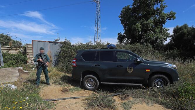 Un guardia civil custodia la entrada de la finca donde se hallaron los dos todoterreno robados en Guadarranque