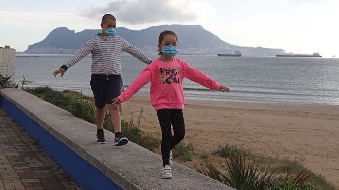 Un niño y una niña juegan por el paseo marítimo de Getares, en Algeciras.