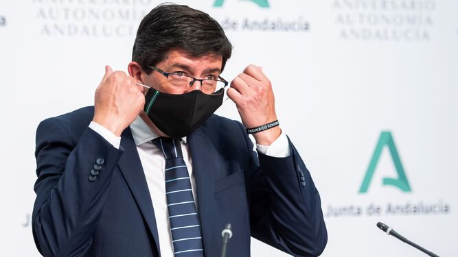Juan Marín se quita la mascarilla antes de la rueda de prensa.
