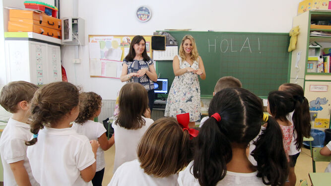 Dos maestras reciben a los alumnos en el primer día de clase.
