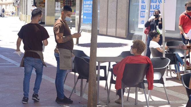 Un camarero atiende a una clienta en Algeciras