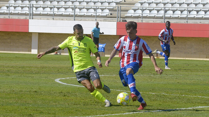 El algecirista Álvaro Romero lleva el balón ante un jugador del Melilla.