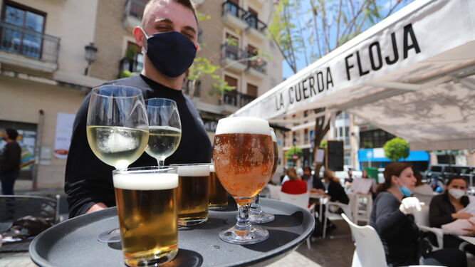 Un camarero sirve en Huelva con mascarilla.