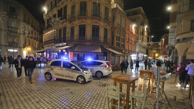 Dos coches de la Policía Local en la plaza del Carbón de Málaga poco antes de las 22:30