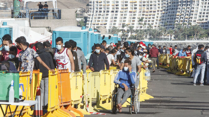 Decenas de inmigrantes haciendo cola en el muelle de Arguineguín (Gran Canaria) este miércoles.