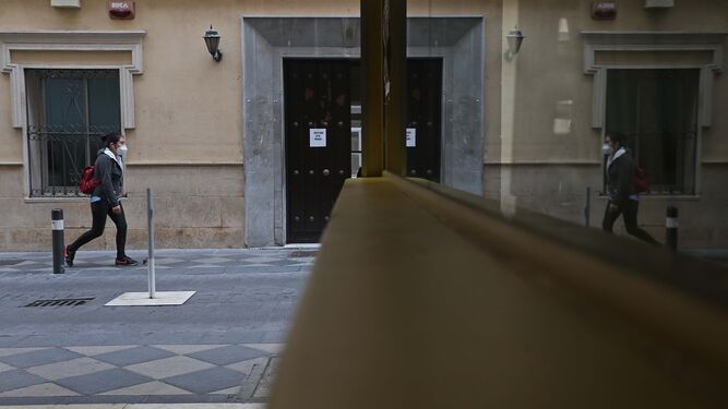 Una mujer camina por el centro de Algeciras con una mascarilla correctamente colocada.