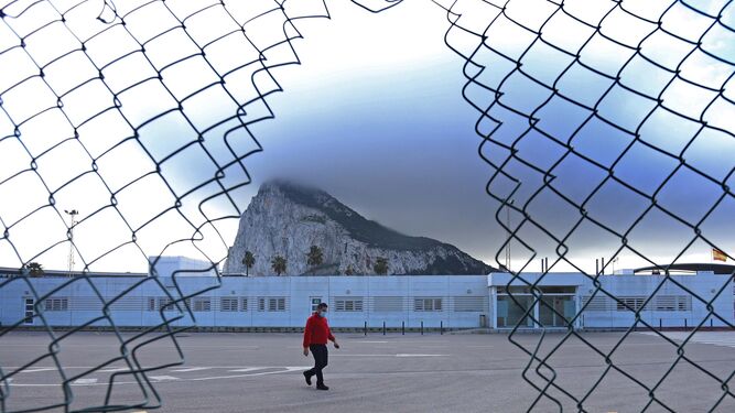 Un agujero en la valla entre España y Gibraltar, tomada este martes, con la zona aduanera del Peñón al fondo.