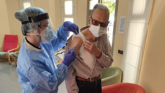 Un usuario de Apadis recibe la vacuna.