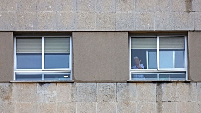 Una enfermera mira por una ventana del hospital Punta de Europa.