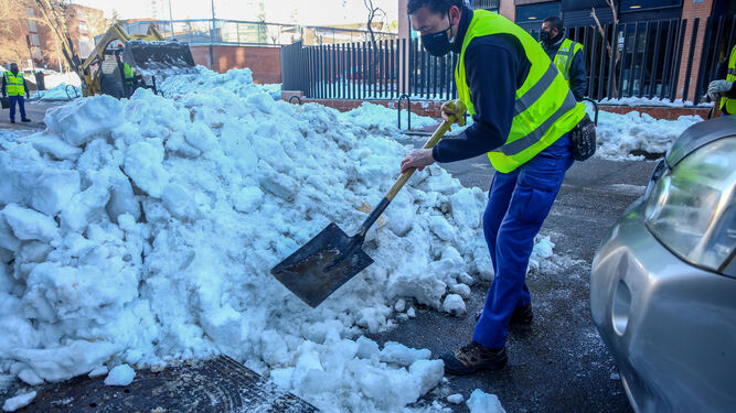 Un operario limpia nieve del alcantarillado de Madrid antes de que comiencen las lluvias en la capital.