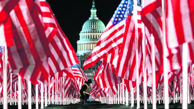Una persona pasa ayer entre las 200.000 banderas instaladas frente al Capitolio para la investidura hoy del demócrata Joe Biden.