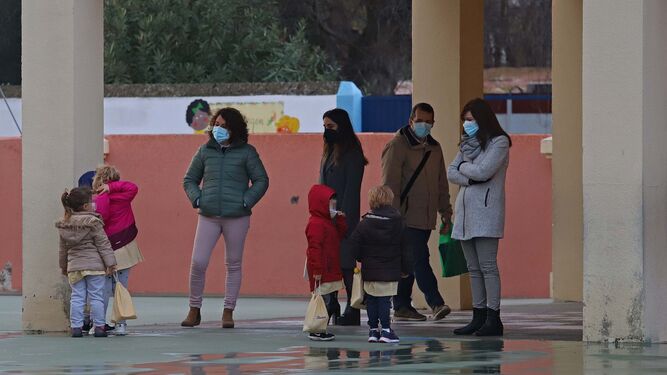 Un grupo de adultos con escolares, a la entrada de un colegio en La Línea