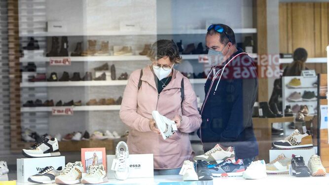 Clientes con mascarillas en una zapatería del centro de Chiclana.