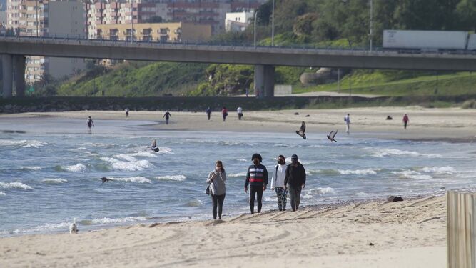 Varias personas caminan por la playa de El Rinconcillo, en Algeciras.