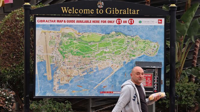 Un hombre camina junto a un mapa de Gibraltar.