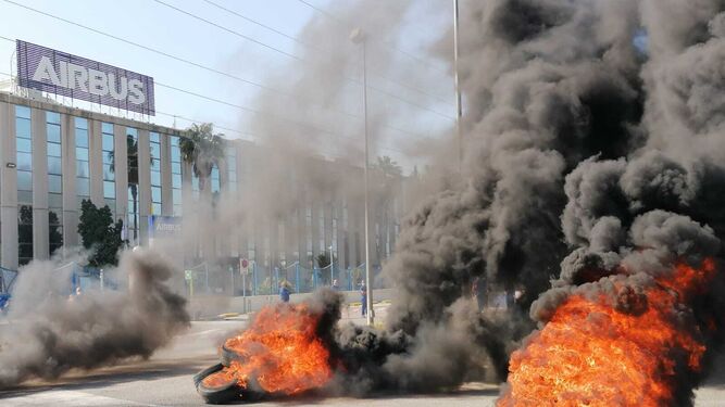 Trabajadores de Airbus queman neumáticos ante la factoría de Puerto Real.