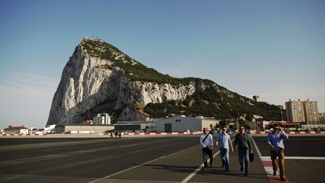Un grupo de personas atraviesa la pista del aeropuerto de Gibraltar.