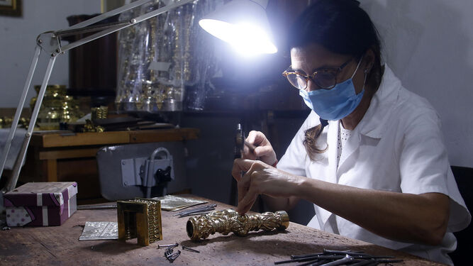 Una joven trabaja en una pieza de orfebrería en el taller de los Hermanos Delgado.