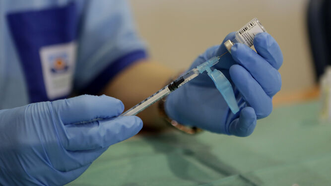 Una enfermera recarga un vial de la vacuna de Pfizer.