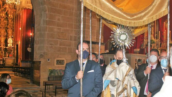 La custodia, portada por el párroco de La Prioral, pasando frente a la capilla de la Virgen de los Milagros.