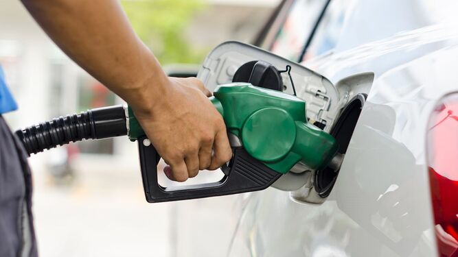 Una persona surte combustible en una gasolinera