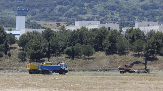 Dos camiones y una excavadora, en los terrenos del futuro CIE de Algeciras.